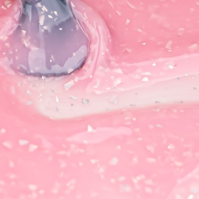 Textura cremosa cor-de-rosa com partículas brancas e uma espátula