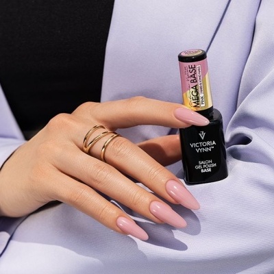 Mãos femininas com unhas rosas segurando dois frascos de esmalte