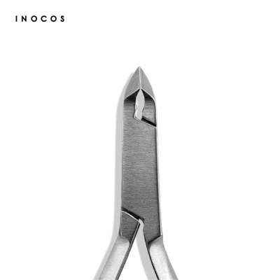 Alicate metálico prateado para cutículas da marca INOCOS sobre fundo branco