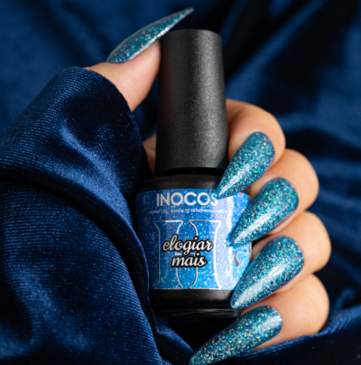 Verniz azul cintilante INOCOS Elogiar Mais com unhas pintadas da mesma cor