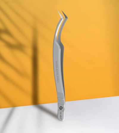 Pinça metálica curva STALEKS PRO PTF-42 sobre superfície branca e fundo laranja