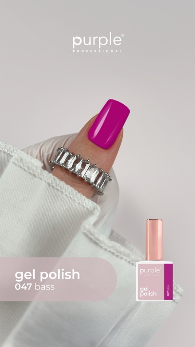 Dedo com verniz gel roxo vibrante e anel prateado com pedras, com frasco de verniz rosa ao lado