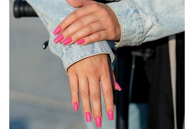 Mãos femininas com unhas rosas e casaco de ganga azul claro