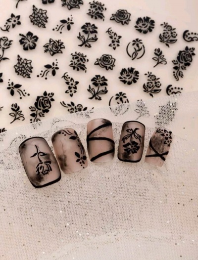 Unhas postiças com decoração floral preta e linhas em fundo translúcido