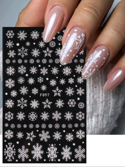 Unhas decoradas com flocos de neve e autocolantes de unhas com padrões de flocos de neve.