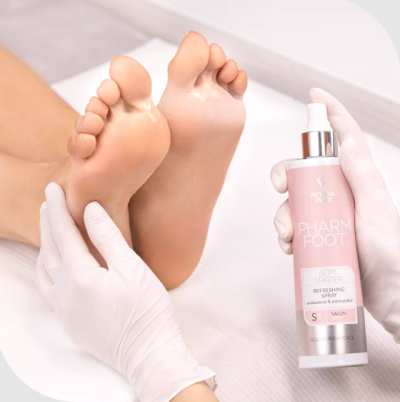 Pés humanos descalços com spray para os pés em frasco cor-de-rosa