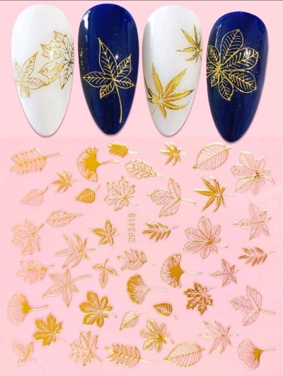 Unhas postiças com decoração dourada de folhas sobre fundo branco e azul escuro, decalques dourados em fundo rosa