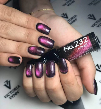 Unhas pintadas com verniz metálico rosa e preto segurando frasco de verniz No. 232 MOKAIT