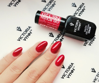 Unhas pintadas de vermelho brilhante e frasco de verniz gel Victoria Vynn vermelho e preto