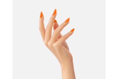 Mão feminina com unhas laranja brilhantes e alongadas em fundo cinzento claro