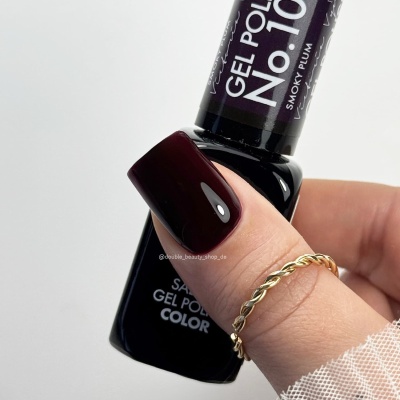 Frasco de verniz gel púrpura escuro com unha pintada e anel dourado trançado