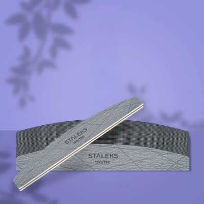 Lima de unhas cinzenta com texto STALEX 150/150 sobre base preta riscada e fundo roxo com sombras.