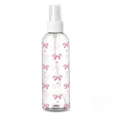Frasco de plástico transparente com pulverizador branco e desenhos rosa de laços e corações