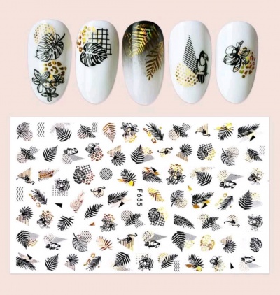 Autocolantes para unhas com desenhos de folhas e flores em preto e dourado sobre unhas postiças brancas