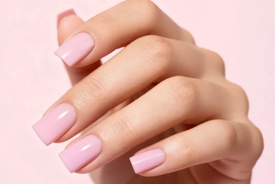 Mão com unhas pintadas de rosa claro