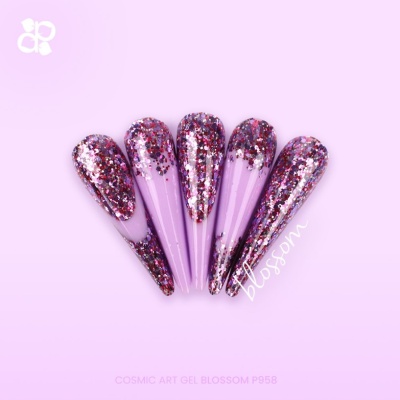 Unhas artificiais longas lilás com glitter rosa, roxo e vermelho sobre fundo rosa claro