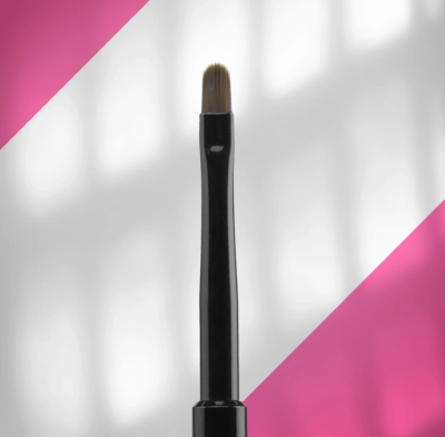 Pincel de maquilhagem com cabo preto e cerdas castanhas sobre fundo branco e rosa