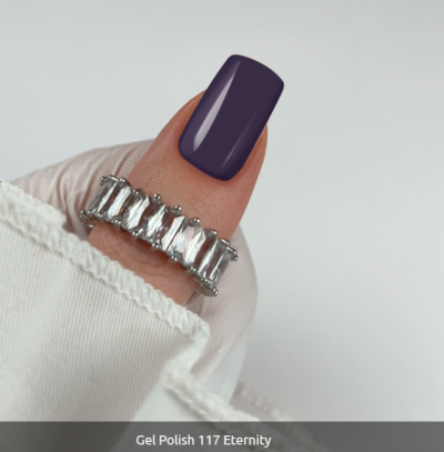 Anel prateado com pedras retangulares e unhas com verniz gel roxo escuro.