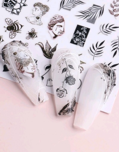 unhas postiças decoradas com desenhos em preto e branco sobre fundo rosa