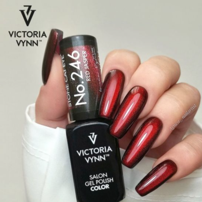 Frasco de verniz gel VICTORIA VYNN e unhas pintadas de vermelho brilhante.