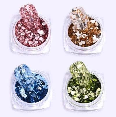 Quatro recipientes com glitter de cores rosa, dourado, azul e verde para unhas