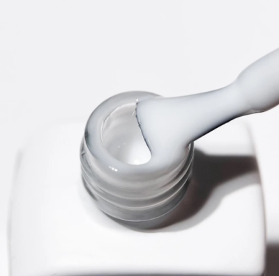 Frasco aberto com pincel e líquido branco