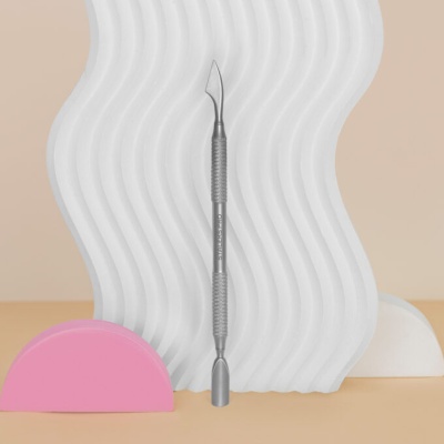 Espátula dupla metálica com fundo branco ondulado e formas coloridas