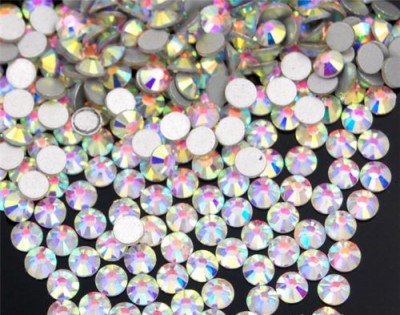 Pedras decorativas facetadas transparentes com brilho iridescente sobre fundo escuro