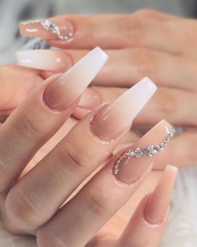 Unhas compridas com gradiente branco para nude e brilhantes prateados