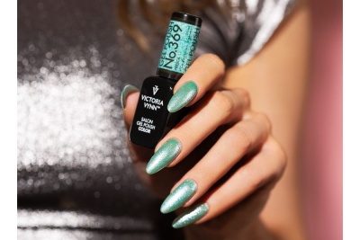 Frasco de verniz de gel Victoria Vynn e unhas pintadas azul cintilante.