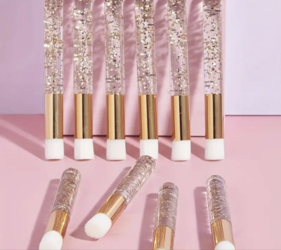 Conjunto de pincéis de maquilhagem com purpurinas douradas em cabos transparentes