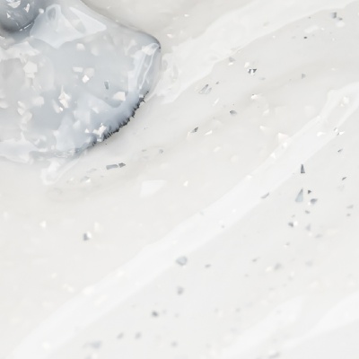 líquido branco com partículas prateadas e objeto azul com textura irregular