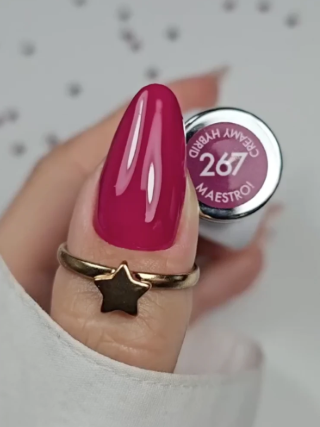 Unha com verniz vinho brilhante e anel dourado em forma de estrela