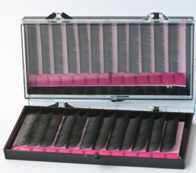 Extensões de pestanas pretas em caixa plástica transparente com interior rosa.