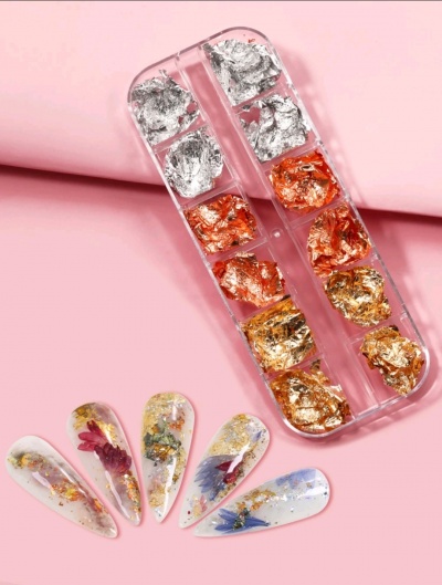 Folhas metálicas decorativas para unhas em embalagem transparente com unhas postiças decoradas.