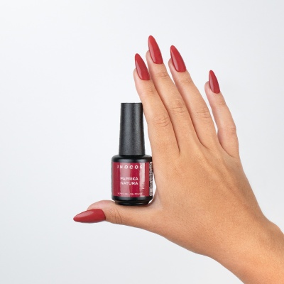 Frasco de verniz de unhas vermelho Paprika Natura com mão mostrando unhas pintadas da mesma cor