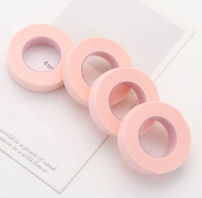 Quatro rolos de fita adesiva rosa sobre papel branco com texto parcial