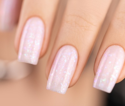 Unhas pintadas com verniz rosa claro translúcido com brilho