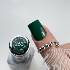 Verniz de unhas verde escuro número 263 da marca Hermani Beauty com unha pintada e anel prateado