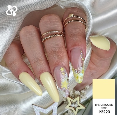 Unhas amarelas pastel e decoradas com estrelas e glitter