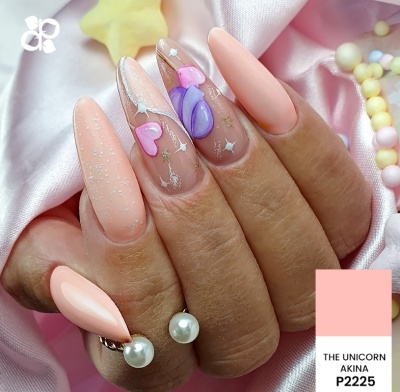Unhas falsas decoradas em rosa, roxo e branco com padrão de corações e estrelas