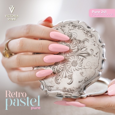 Mãos com unhas pintadas de rosa pastel segurando espelho de bolso dourado com padrão floral