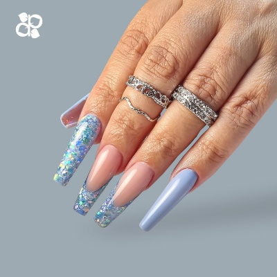 Mãos femininas com unhas longas decoradas e anéis prateados