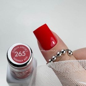 Unha vermelha brilhante com anéis prateados e frasco de verniz com tampa rotulada 265 MAMMA MIA