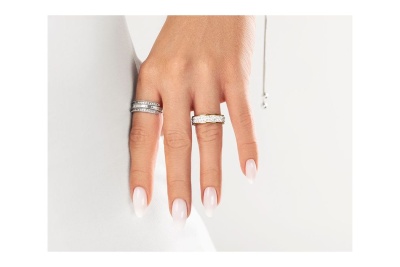 Mão feminina com dois anéis em fundo branco