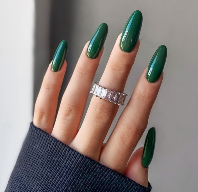 Mão com unhas verdes longas e anel prateado com pedras retangulares