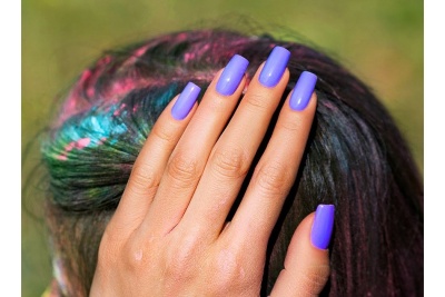 Mão com unhas roxas e cabelo colorido