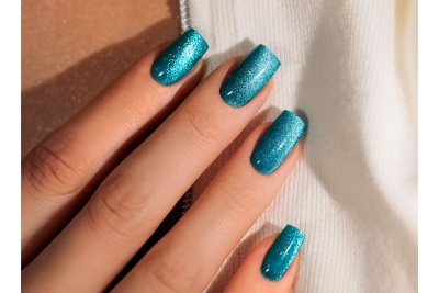 Unhas com esmalte azul turquesa brilhante em mão feminina
