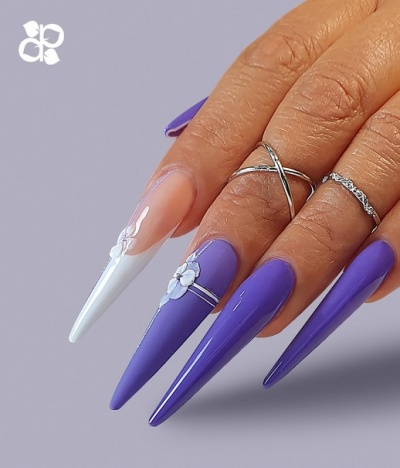 Unhas compridas stiletto roxas e brancas com decoração floral e anéis prateados