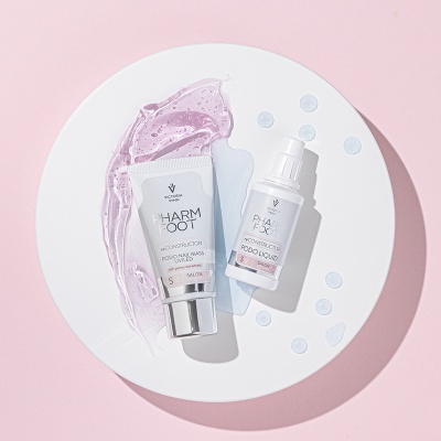 produtos cosméticos Pharm Foot sobre prato branco com gel lilás e gotas de líquido sobre fundo rosa